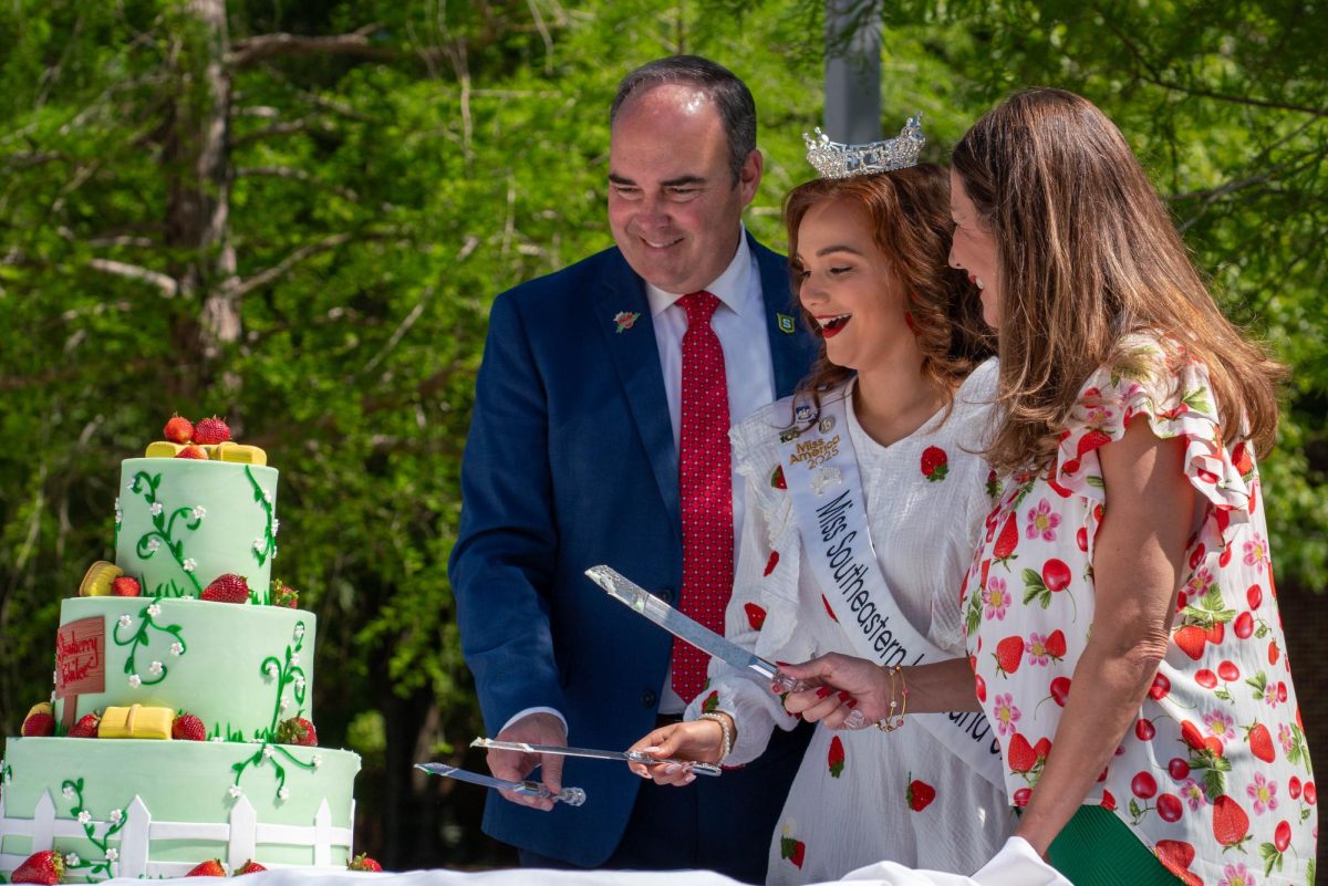 Miss Southeastern Eva Delatte, SLU President Dr. William Wainwright and First Lady Misty Wainwright kick off Strawberry Jubilee with the traditional cake cutting.