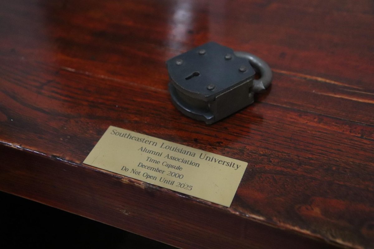 A brown table with a lock and a gold plate with words telling people not to open until 2025.