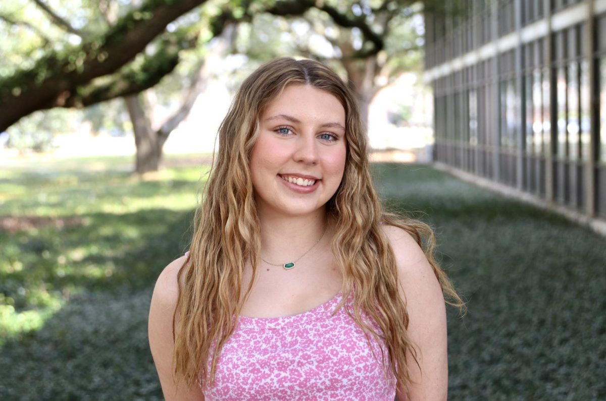 a woman with a pink shirt posed with a blurred background