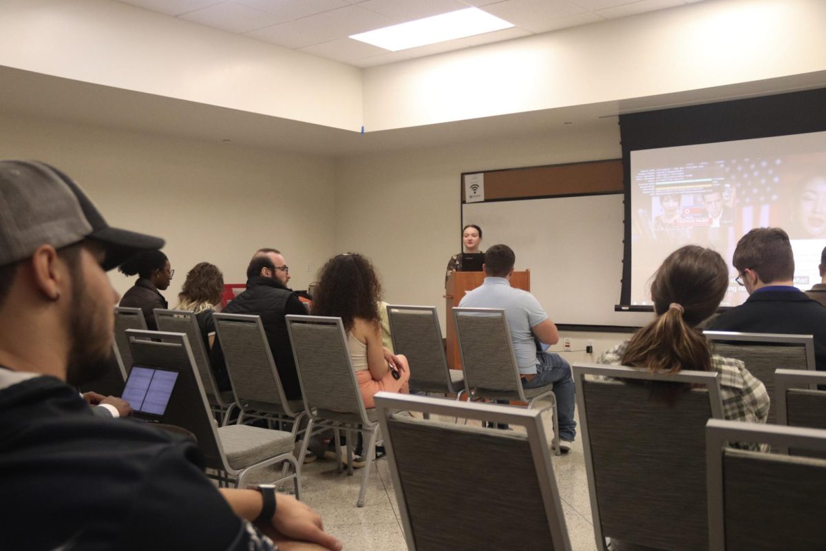 People sitting in a room looking at a screen.