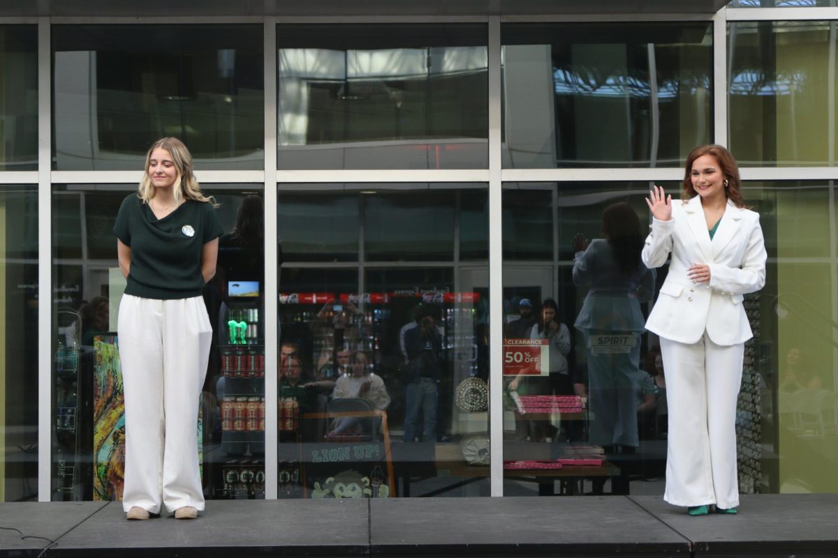 Two people stand on a stage.
