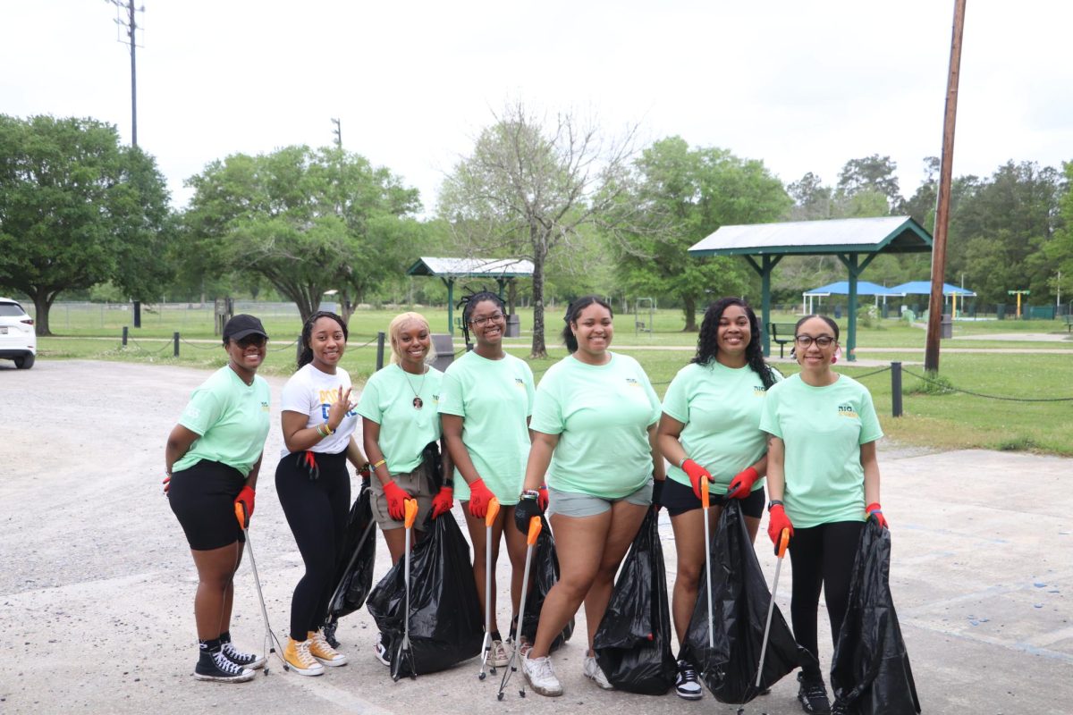 a group of women pose at a trash cleaning event
