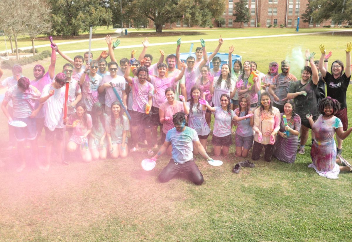 Students gathered around cover in many colors from color powder.