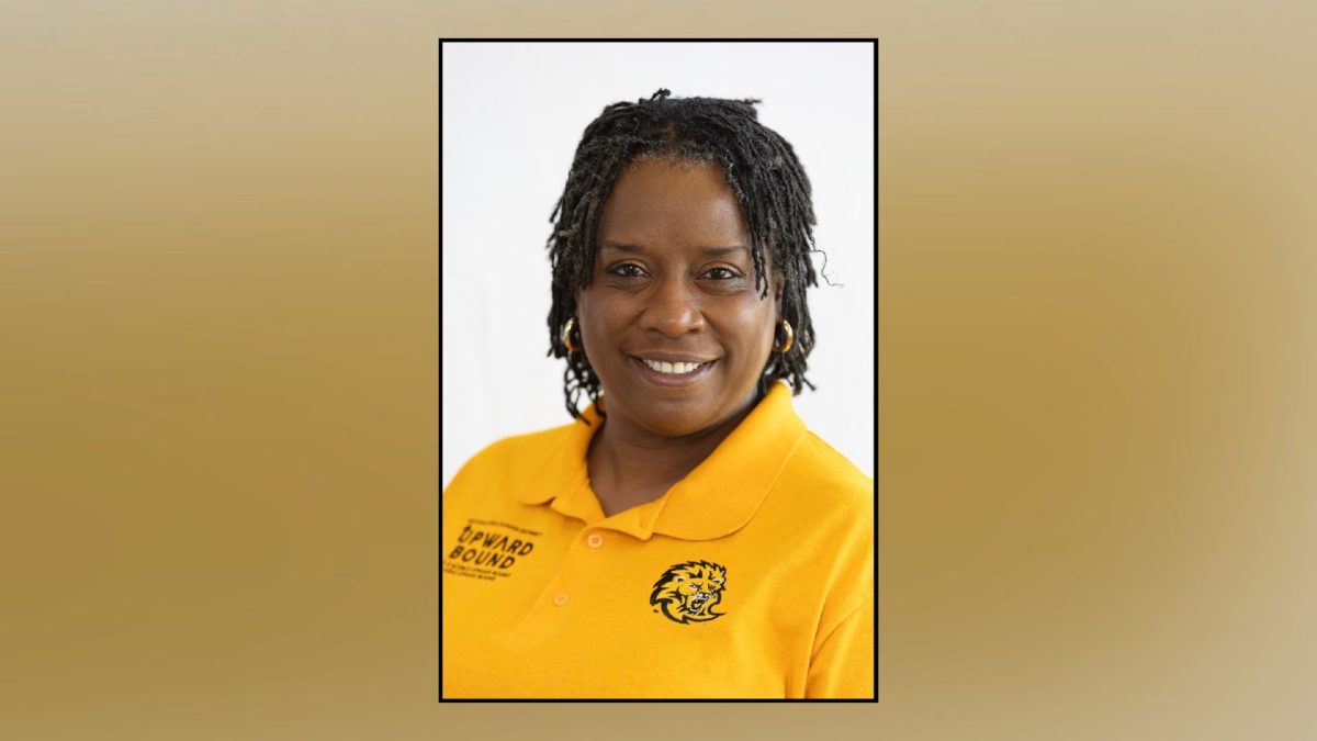 A woman in a yellow shirt over a green background.